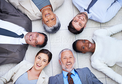 Buy stock photo High angle portrait of a group of diverse businesspeople lying on the floor in a circle