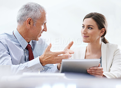 Buy stock photo Cropped shot of two coworkers using a digital tablet at work