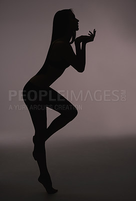 Buy stock photo Dancer, woman and silhouette with beauty, body care and sensual on a dark studio background. Person, profile and model with shadow figure and seductive with wellness and natural pose with slim girl