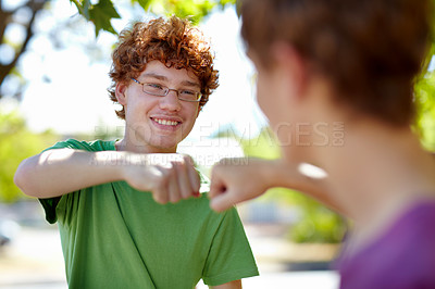 Buy stock photo Cropped shot of two teenage boys fist bumping