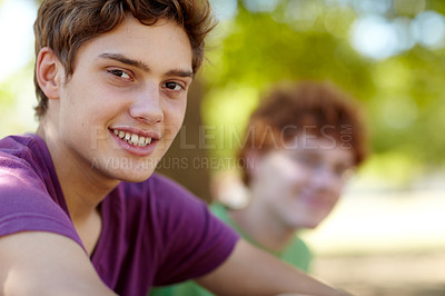 Buy stock photo Portrait of two teenage boys sitting in a park on a sunny day