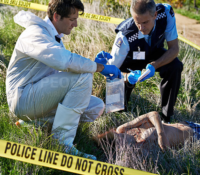 Buy stock photo Shot of a policeman and a forensic investigator collecting evidence