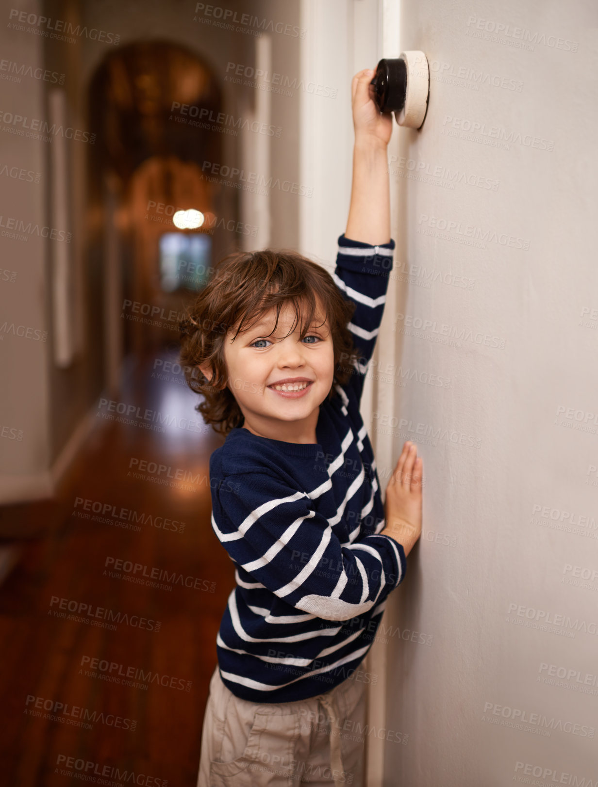 Buy stock photo A cropped shot of a little boy switching a light off in his home