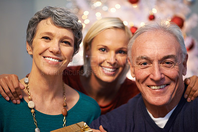 Buy stock photo Christmas, tree and senior family in portrait with love, happy and gratitude for holiday and tradition at night. Face of elderly parents with daughter and gift, present and celebration at their home