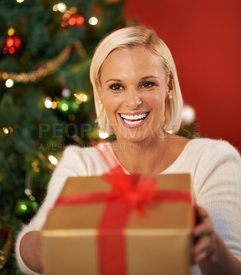 Buy stock photo Christmas, gift and woman giving for holiday surprise, celebration and tradition at night. Excited, happy and young person by tree and bokeh lights with present, box and thanksgiving or love at home