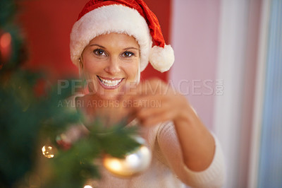 Buy stock photo Cropped shot of a woman in a christmas hat decorating a tree