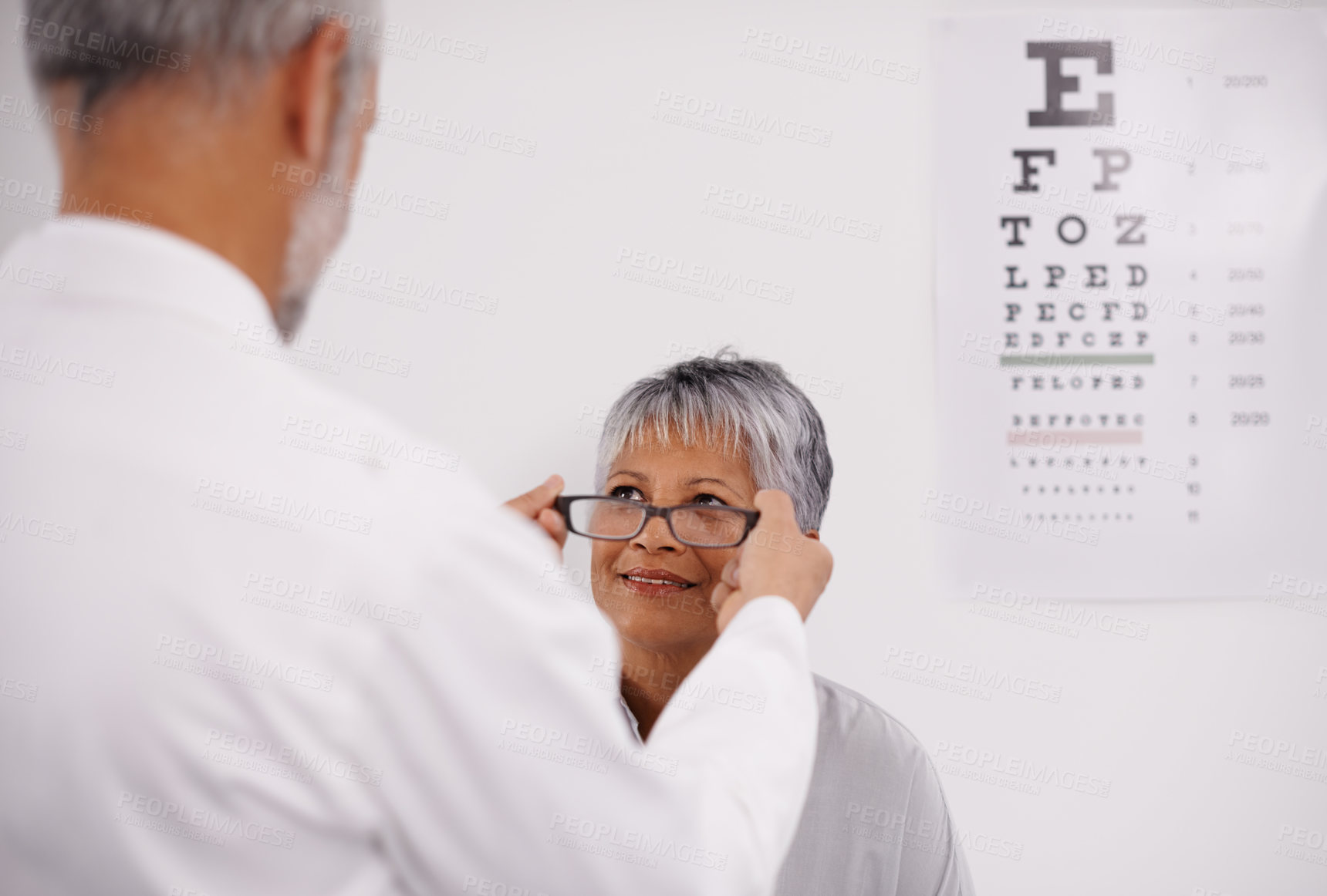 Buy stock photo Optometrist doctor, elderly patient and glasses for vision, eye exam in medical consultation at optometry practice. Prescription lens, frame and senior man help woman in clinic with health insurance