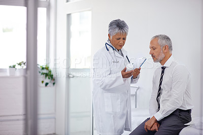 Buy stock photo A mature doctor giving a bottle of pills to one of her patients during a checkup