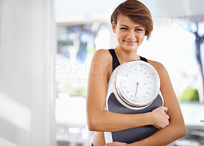 Buy stock photo A beautiful young woman standing holding a scale
