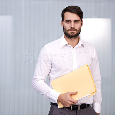 Buy stock photo Shot of a handsome young man holding a folder in an office