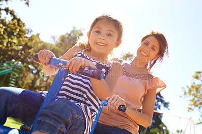 Buy stock photo Shot of a young mother and daughter playing on a seesaw together