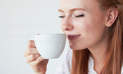 Buy stock photo Face of woman smell her cup of coffee in a studio for a scent in the morning on a weekend. Calm, relax and female model enjoying the aroma of a cappuccino, caffeine or latte by a white background.