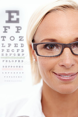 Buy stock photo A cropped shot of a beautiful optometrist in front of a snellen chart