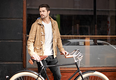 Buy stock photo Cropped shot of a fashionable young man walking with his bicycle