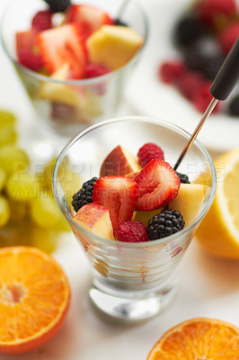 Buy stock photo Fruit salad, breakfast and healthy food or diet in studio with color, art and creativity. Nutritionist, wellness and fruits for vegan snack with berry, apple and orange ingredient on a white table