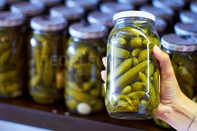 Buy stock photo Woman, hand and jar of pickles in store for product selection or choice, shelf and shopping for condiments. Person, gherkins and glass with vegetable in vinegar, organic and nutrition for health.