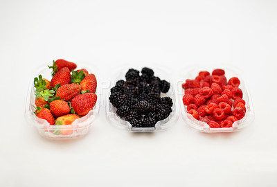 Buy stock photo Studio shot of strawberries, raspberries and blackberries in separate containers.