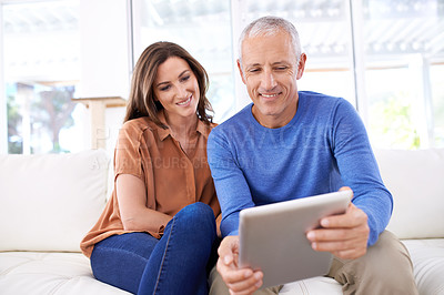 Buy stock photo Couple, tablet and happy on sofa to relax with reading, search or app for bonding in home living room. People, woman and mature man on digital touchscreen on lounge couch with web streaming in house