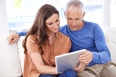Buy stock photo Cropped shot of a happy couple at home using their digital tablet together