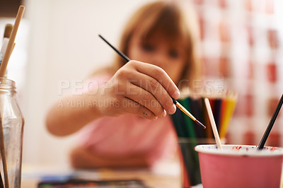 Buy stock photo A little girl dipping her paintbrush in water