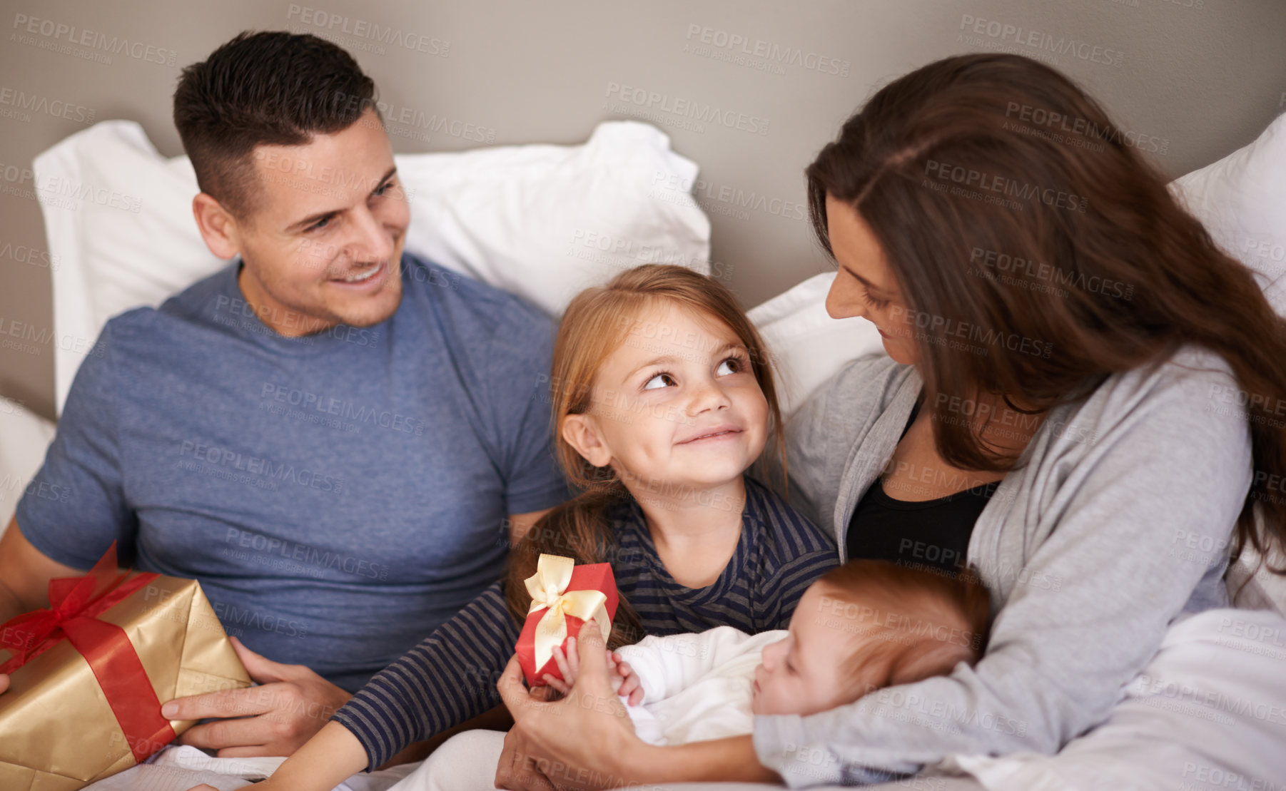 Buy stock photo Bedroom, gift or family with celebration, home or bonding together with happiness, Christmas or festive season. Parents, mother or father with children, excited or kids with presents, morning or Xmas