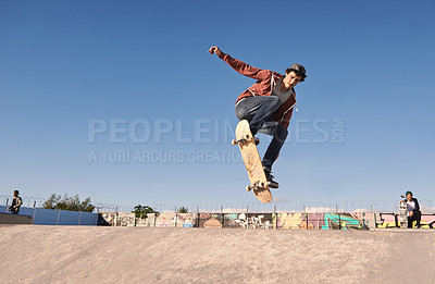 Buy stock photo A young man doing tricks on his skateboard at the skate park