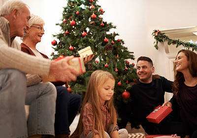 Buy stock photo Family, present and christmas at home with love, giving and care together at holiday event. Happy, smile and tree with celebration, child and marriage in a house with grandparents and festive gift