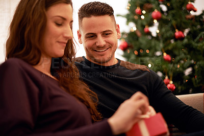 Buy stock photo Gift, christmas and couple relax together for holiday festive celebration. Happy, smile and surprise present box to celebrate xmas, love and happiness on sofa in living room with christmas tree
