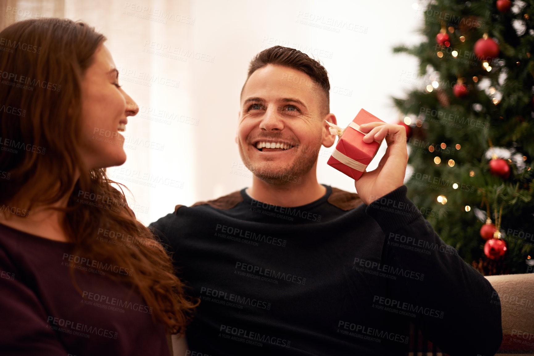 Buy stock photo Couple, Christmas and love with guess gift box for surprise, happiness and holiday excitement. Happy, marriage and present for partner guessing what is inside with cheerful smile in home.
