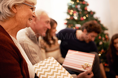 Buy stock photo Christmas, gift and happy with family in living room for celebration, festive and holiday. Smile, party and gratitude with old woman and present with children at home for giving, event and tradition