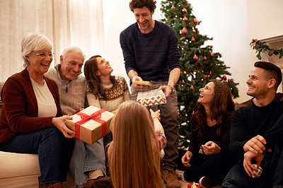 Buy stock photo Christmas, happy and gift with family in living room for for celebration, holiday and festive gratitude. Relax, smile and present with parents giving box to children at home for content on xmas party