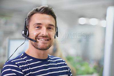Buy stock photo Shot of a young businessman wearing a headset in the office
