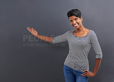 Buy stock photo Happy woman, portrait and presentation with advertising or marketing on a gray studio background. Female person or Indian with smile for notification, alert or special deal on fashion or mockup space