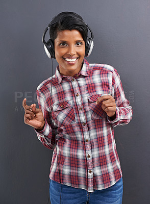 Buy stock photo Happy woman, portrait and dancing with headphones for music or podcast on a gray studio background. Young female person or Indian with smile enjoying or listening to audio or sound track with headset