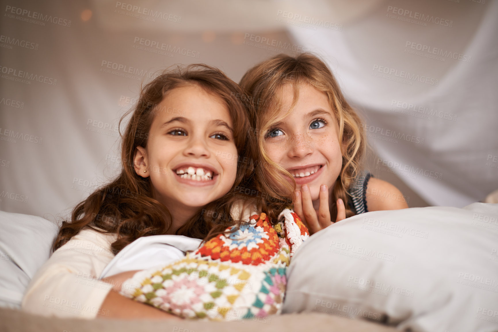 Buy stock photo Happy, sleepover and face of children in bedroom for playing, bonding and relax with toys in home. Laughing, friends and young girls on bed in tent or blanket fort for childhood, fun and happiness