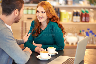 Buy stock photo A loving young couple drinking coffee while sitting with a laptop in a cafe