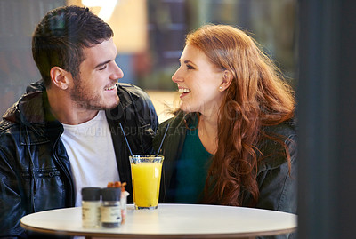 Buy stock photo Couple, smile and eye contact in restaurant with love, romance and affection on anniversary date. Romantic, man and woman in cafe bonding with juice, beverage and laughter in relationship for dating