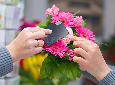 Buy stock photo Cropped shot of a woman buying flowers with her credit card from a florist