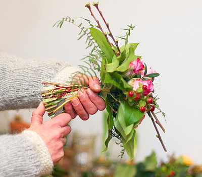 Buy stock photo Cropped view of a florist's hands as she prepares a bouquet of flowers