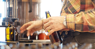 Buy stock photo Shot of beer bottles being filled at a brewery