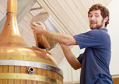 Buy stock photo Shot of a man adding ingredients to a copper tun in a brewery