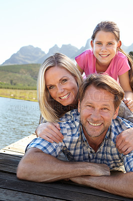 Buy stock photo Smile, lake and portrait of family in nature for summer vacation, weekend trip and bonding together. Man, woman and relax with daughter outdoors for happiness, adventure and tourism travel in Europe