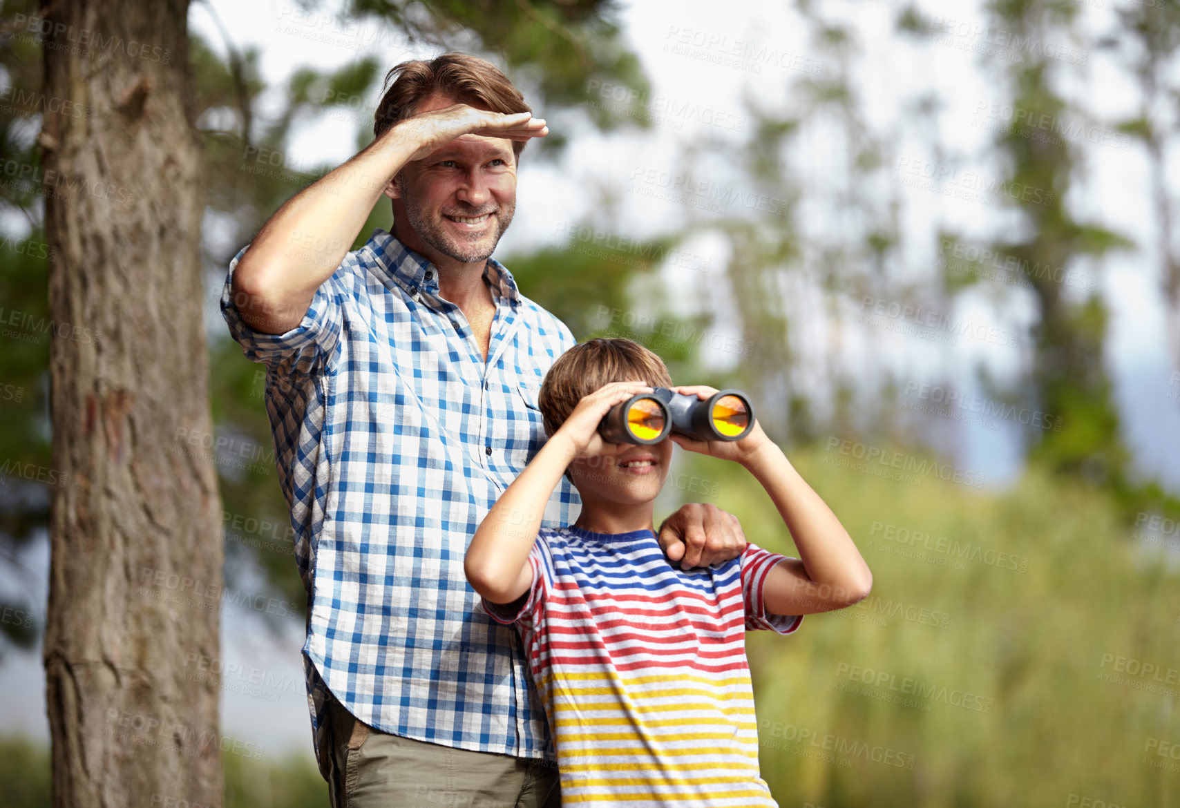 Buy stock photo Father, son and binoculars in nature for outdoor adventure, birdwatching and learning by trees with smile. Dad, child and support for vision, view and search for connection, care or bonding in forest