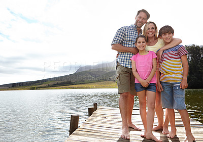 Buy stock photo Family, portrait by lake and outdoor on pier for travel with vacation, parents and kids with fresh air in nature for bonding. Love, support and trust, happy people and adventure together with smile