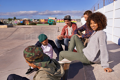 Buy stock photo Shot of a group of friends socializing at the skatepark
