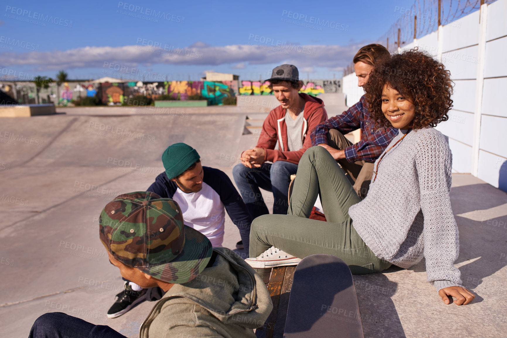 Buy stock photo Shot of a group of friends socializing at the skatepark