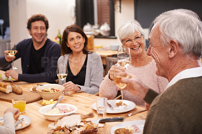 Buy stock photo Happy, cheers and family at supper in dining room for party, celebration or event at modern home. Smile, bonding and people enjoying meal, dinner or lunch together with wine for toast at house.