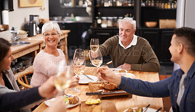 Buy stock photo Cheers, wine and family at dinner in dining room for party, celebration or event at modern home. Smile, bonding and group of people enjoying meal, supper or lunch together with champagne at house.