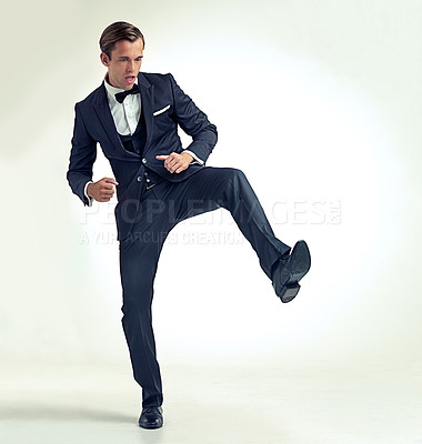 Buy stock photo Businessman, kick and studio confidence in suit or career opportunity with growth goals, white background or mockup space. Male person, leg and classy bowtie as professional for job, formal or event