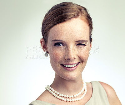 Buy stock photo Portrait, fashion and happy woman wink in studio isolated on white background mockup space. Face, freckles or smile of young female person in vintage clothes for style with pearl necklace in Ireland